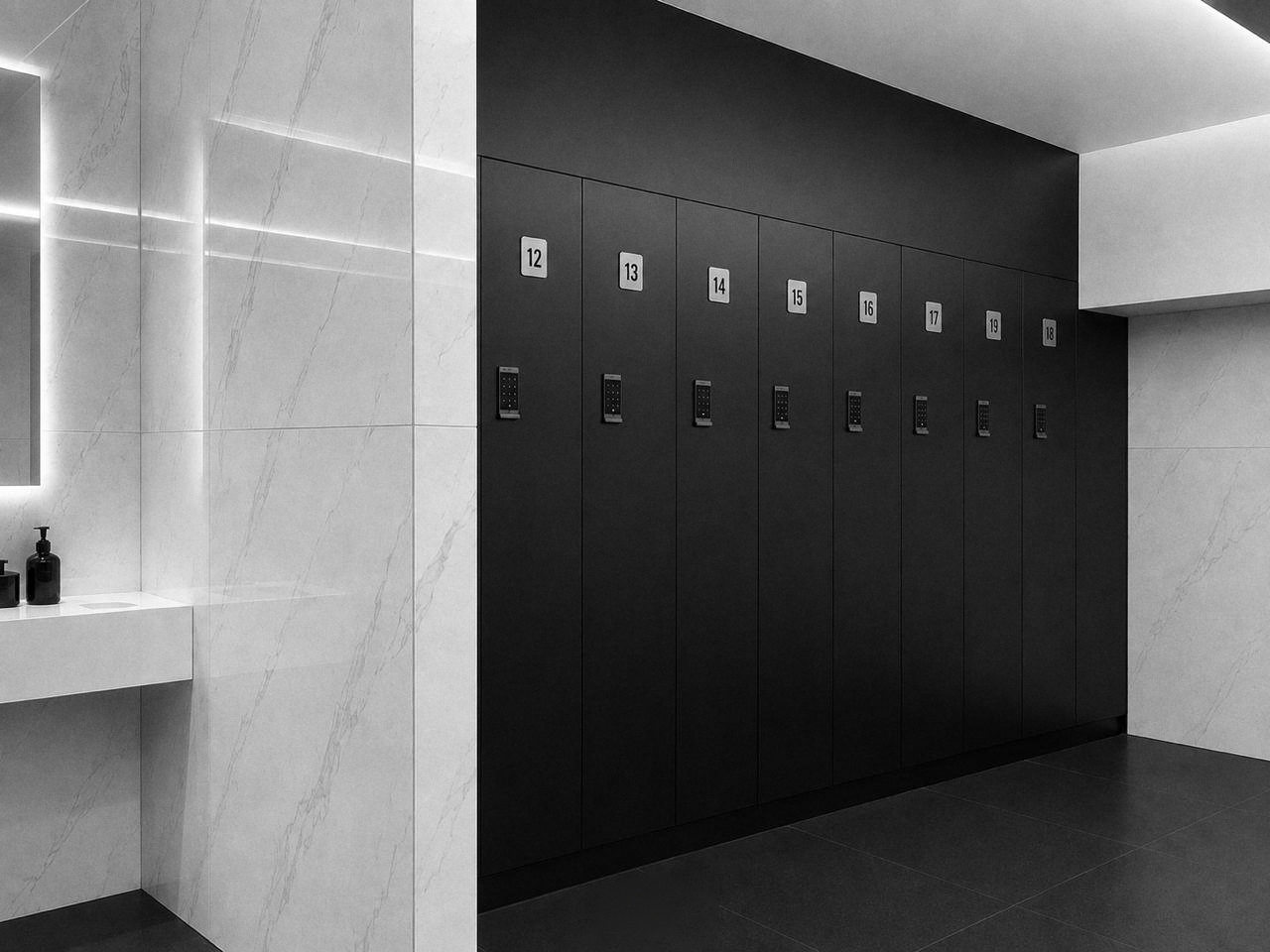 Casiers noirs numérotés et un plan en marbre dans le vestiaire.