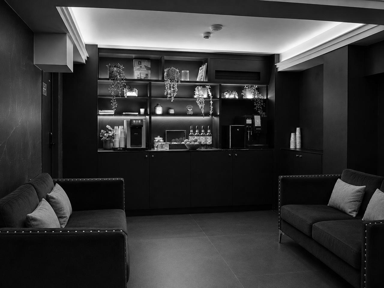 Le salon d'attente : deux canapés, des étagères et une fontaine à eau.