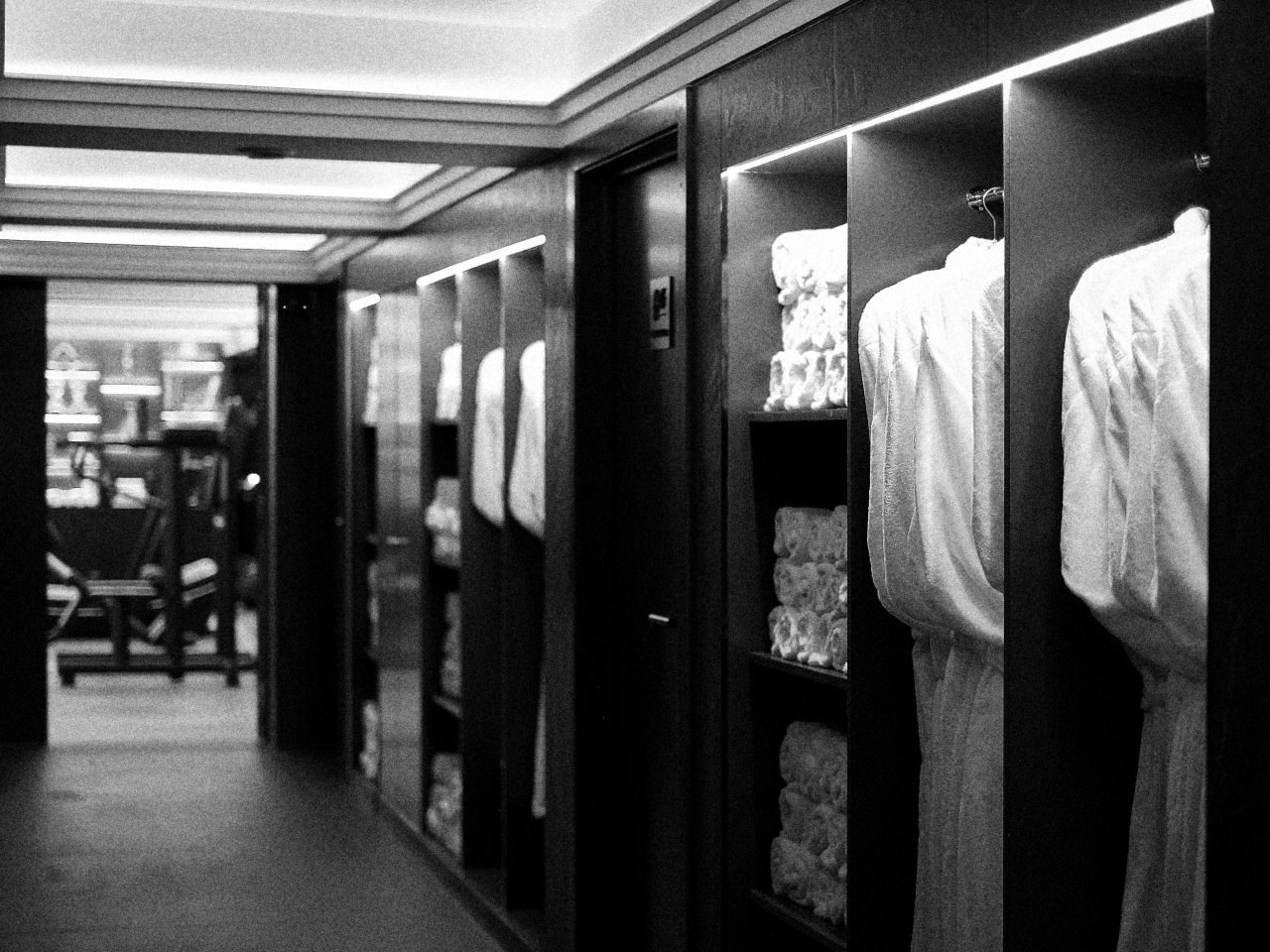 Peignoirs et serviettes roulées dans le couloir du vestiaire.
